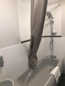 a bath tub with a shower curtain in a bathroom at The Wheatsheaf Inn in Cuckfield