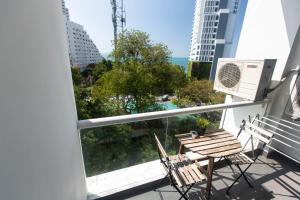 een balkon met een tafel en stoelen en uitzicht op de oceaan bij Serenity Condo Wongamat by Patsamon in Noord Pattaya