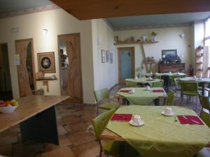 a restaurant with green tables and chairs and a room at Hotel Il Roscio in Attigliano