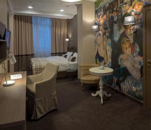 ein Hotelzimmer mit einem Schlafzimmer mit einem Bett und einem Tisch in der Unterkunft ZENTRUM Hotel in Chişinău