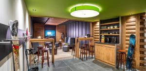 a room with a bar and some stools in it at Residence Amaya in Villard-sur-Doron