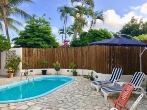 a swimming pool with two chairs and an umbrella at Antheia Ponta do Seixas in João Pessoa