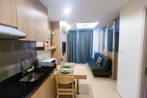 a kitchen with a couch and a table in a room at The Chezz by Patsamon in Pattaya Central