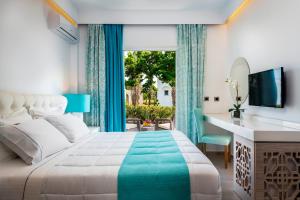 1 dormitorio con cama, escritorio y ventana en Smy Kos Beach & Splash, en Mastichari