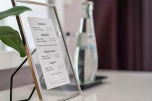 Empress Boutique Hotel في ميونخ: وضع علامة على طاولة بجوار زجاجة زجاجية