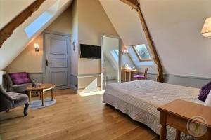 sypialnia z łóżkiem, kanapą i telewizorem w obiekcie Gentilhommière de la Grande Toutenais w Saint-Malo