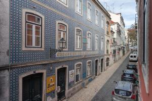 a blue and white building with cars parked on a street at Bairro Alto Guesthouse in Lisbon
