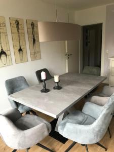 a dining room table with chairs and candles on it at Familienfreundliche Ferienwohnung für 4 Personen in Lutzerath
