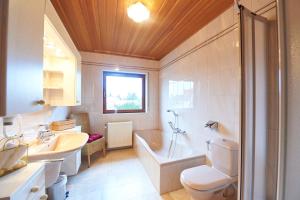 uma casa de banho com uma banheira, um WC e um lavatório. em Gästehaus Achenbach em Wonsheim