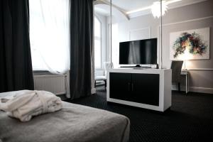 a hotel room with a bed and a flat screen tv at Aparthotel Platinum Apartamenty in Inowrocław