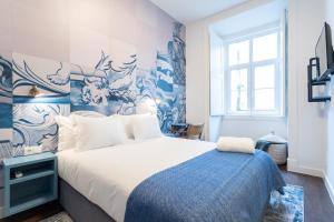 a bedroom with a bed with blue and white wallpaper at Bairro Alto Guesthouse in Lisbon +59 photos