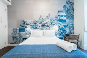 a bedroom with a bed with a blue and white wall at Bairro Alto Guesthouse in Lisbon