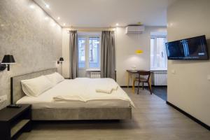 sypialnia z łóżkiem i telewizorem w obiekcie Modern Apartments on Baseina near Arena City w Kijowie