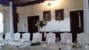 Cette chambre comprend une table avec des tables blanches et des chaises blanches. dans l'établissement Pałac Myśliwski w Antoninie, à Antonin