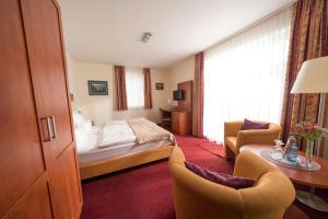 a hotel room with a bed and a desk and chairs at Hotel & Café Strandeck in Prerow