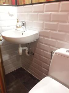 een badkamer met een witte wastafel en een toilet bij Apartament Basarab in Lviv