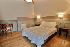 een slaapkamer met een bed, een tafel en een stoel bij Gîte le Grand Bé in Saint-Malo
