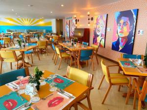 Pop Art Hotel Manizales Centro Histórico في مانيزاليس: غرفة طعام مع طاولات وكراسي خشبية