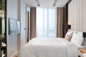 伊斯坦布尔WestSide Residences by Rotana的卧室里有一张白色的大床和一扇窗户