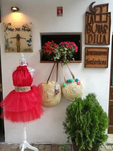 a display of baskets and a dress on a wall at Apartamentos La Buhardilla in Ezcaray