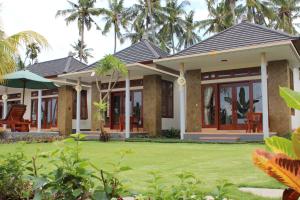 a house with a lawn in front of it at Villa Umah Didua in Lovina