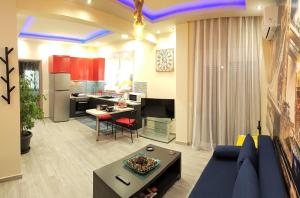 a living room with a blue couch and a kitchen at Betty's Central Suite in Alexandroupoli