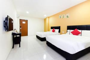 a hotel room with two beds and a television at Central Hotel in Bahau