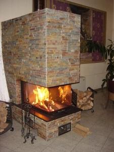 a brick fireplace with a fire in it at Hotel Theresia in Kolín