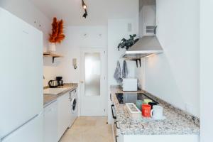 a kitchen with white cabinets and a counter top at Reformed and bright- 2Bdr 1Bth- Nervion in Seville
