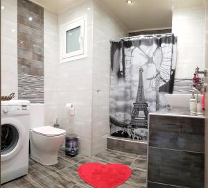 uma casa de banho com um WC e um chuveiro com a Torre Eiffel em Betty's Central Suite em Alexandroúpolis