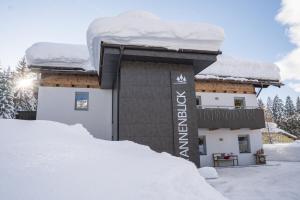 budynek pokryty śniegiem z napisem w obiekcie Ferienhaus Tannenblick w mieście Leutasch