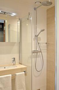 y baño con ducha y lavamanos. en Forenom Serviced Apartments Göteborg Geijersgatan en Gotemburgo