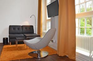 a living room with a chair and a couch at Forenom Serviced Apartments Göteborg Geijersgatan in Gothenburg