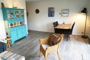 a living room with a table and a blue cabinet at Strandslag Juliana 135 in Julianadorp