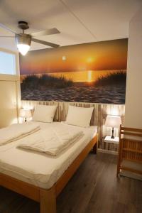 a bedroom with a bed with a painting on the wall at Strandslag Juliana 135 in Julianadorp