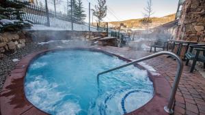 a hot tub with a metal rail in a yard at Zephyr Slopeside - 1504 condo in Winter Park