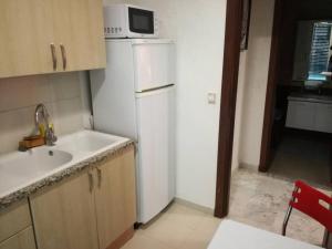 a kitchen with a white refrigerator and a microwave at Moderne & fabuleux appart in Tunis