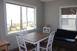 Shoreline Suites & Cabana Cottages – Beachfront في دايتونا بيتش: غرفة طعام مع طاولة وكراسي ونافذة