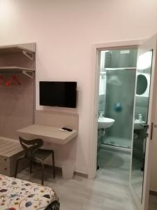 una camera da letto con scrivania e un bagno con lavandino di The Luxury Erica's Apartment a Napoli