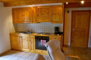 a kitchen with wooden cabinets and a stove at Casa Uccellini in Vogorno