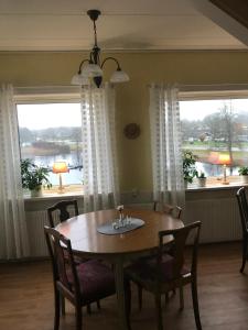 a dining room with a table and chairs and windows at Fegens Vandrarhem in Fegen