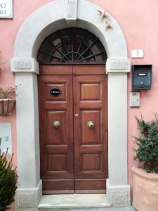 a wooden door with an arch in a pink building at I Ninni in Castiglione del Lago