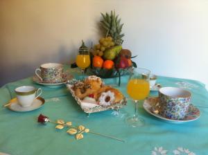 una mesa con un paño de mesa azul con una mesa con fruta y bebidas en Residenza Guarna, en Salerno
