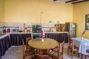 Go-Inn Hotel في تارابوتو: مطبخ مع طاولة خشبية وطاولة وكراسي