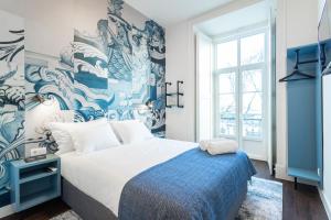 a bedroom with a large bed with a blue and white wall at Bairro Alto Guesthouse in Lisbon