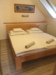 ein Schlafzimmer mit einem Bett mit zwei Kissen darauf in der Unterkunft Anonim apartman in Villány