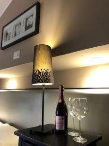 ローマにあるホテル カサーレ デイ マッシミのワイン1本、テーブルの上にランプ