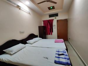 1 Schlafzimmer mit 2 Betten und einem Fenster in der Unterkunft Sakthimurugan residency in Erode