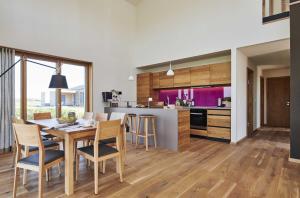 uma cozinha e sala de jantar com mesa e cadeiras em Gud Jard Chalet Nr 07 - Design-Ferienhaus mit exklusiver Ausstattung em Pellworm
