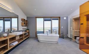 uma grande casa de banho com 2 lavatórios e uma banheira em Gud Jard Chalet Nr 07 - Design-Ferienhaus mit exklusiver Ausstattung em Pellworm